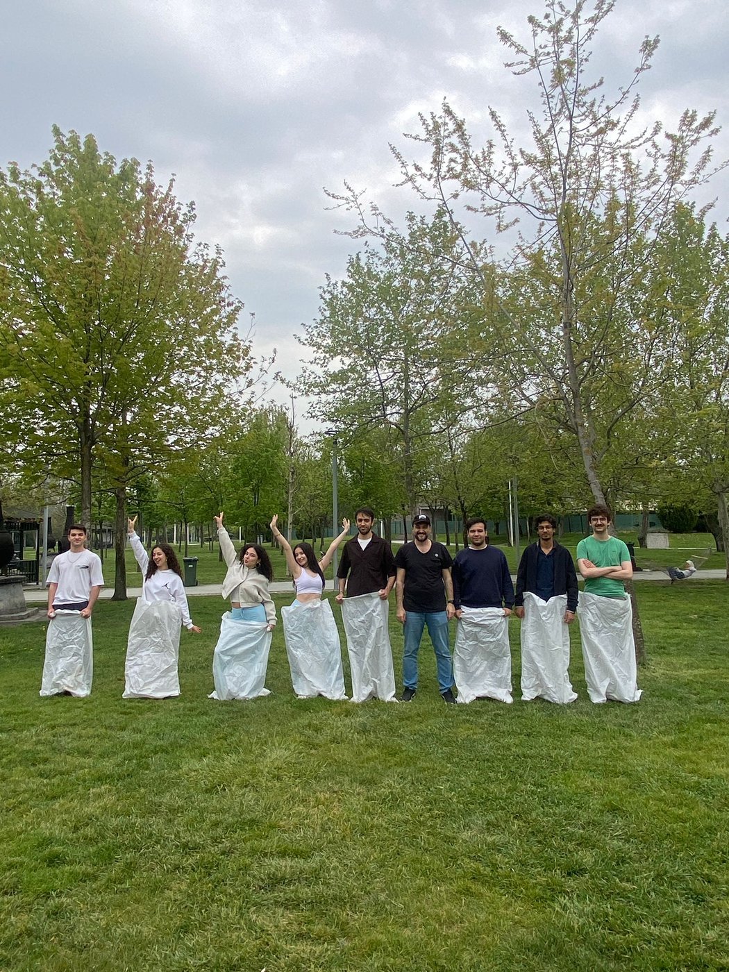 During the sack race, students compete while Assoc. Prof. Dr. Yenal Arslan follows the event as a referee.