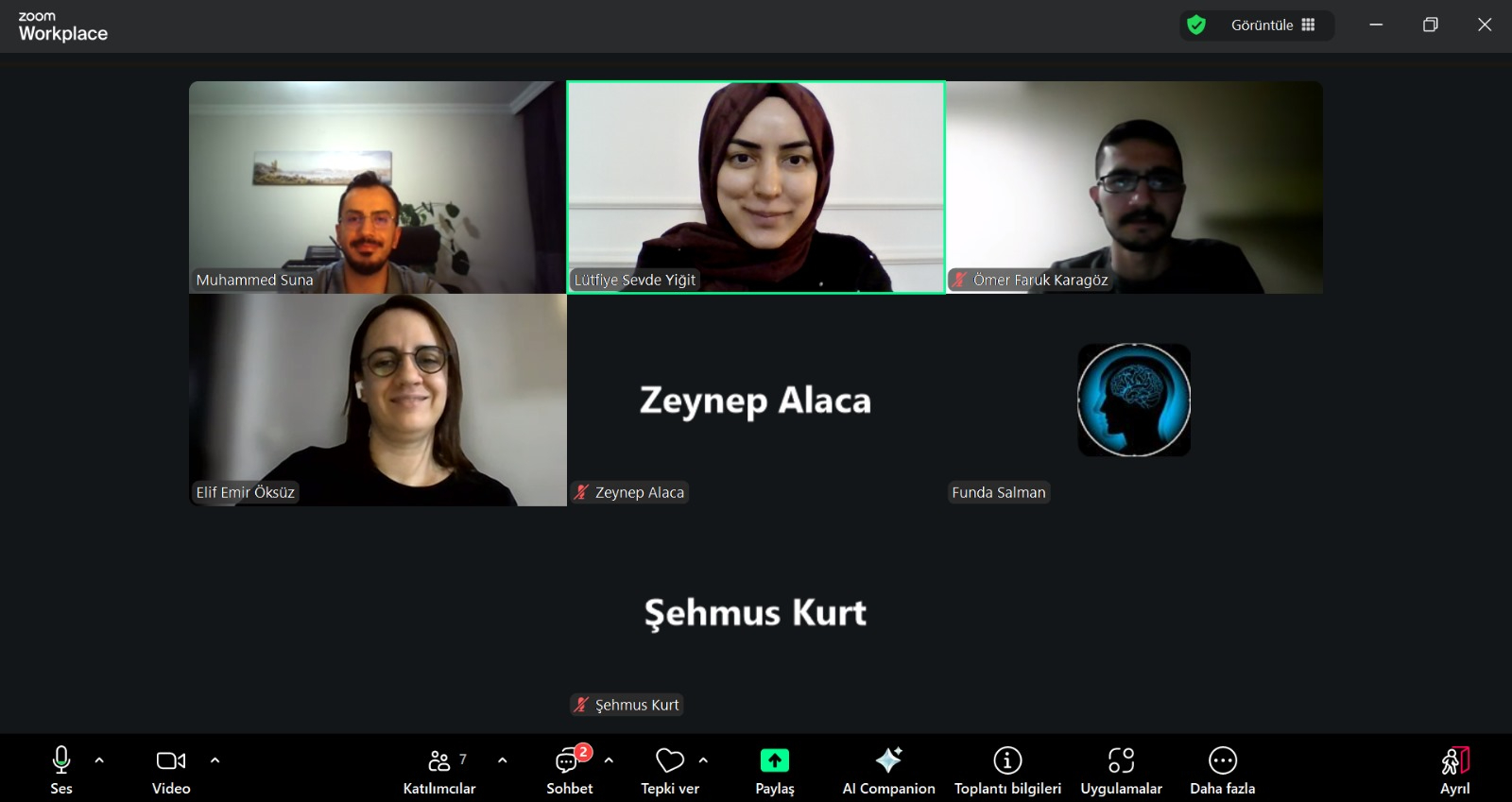 TR: Çevrimiçi bir toplantı ekranında üç katılımcı, profil isimleri ve toplantı yönetim menüsü görülmektedir. EN: Three participants, profile names, and the meeting management menu are displayed on an online meeting screen.