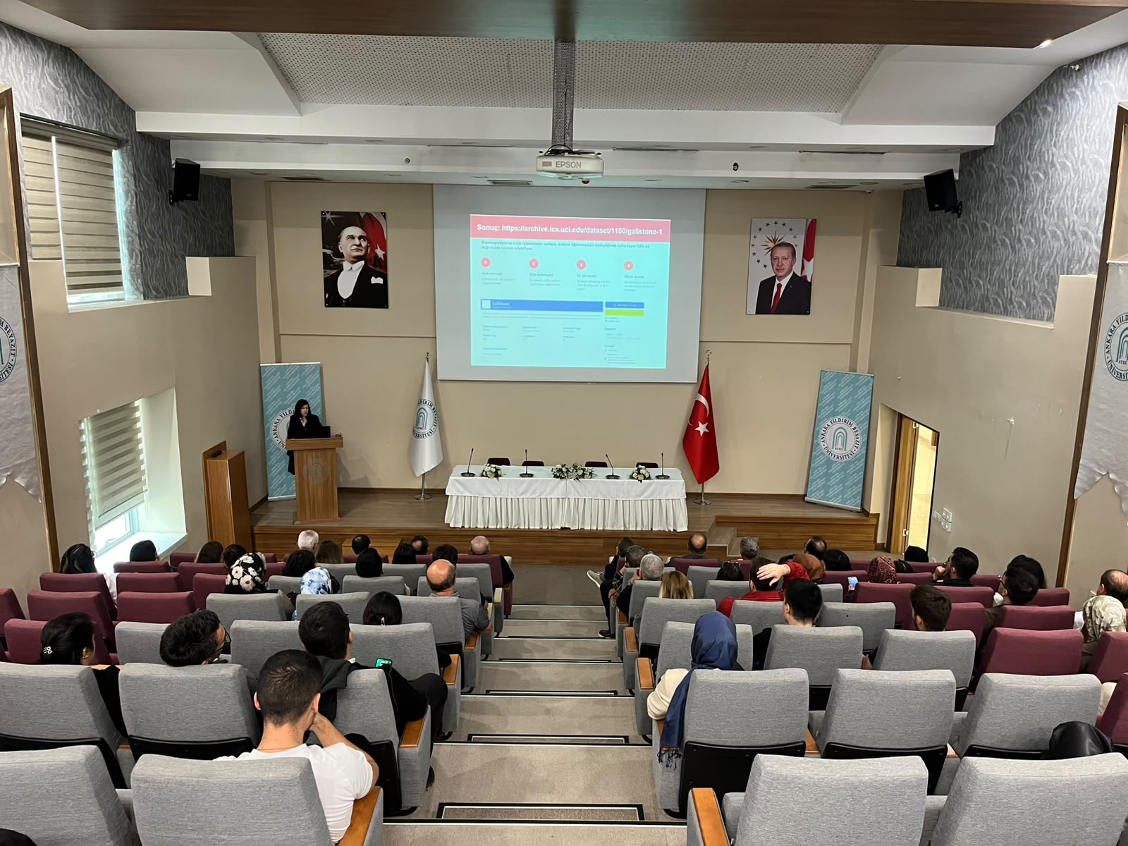 Doç. Dr. Hilal Arslan konuşmasını yaparken dinleyicilerile birlikte salonun arkadan fotoğrafı.