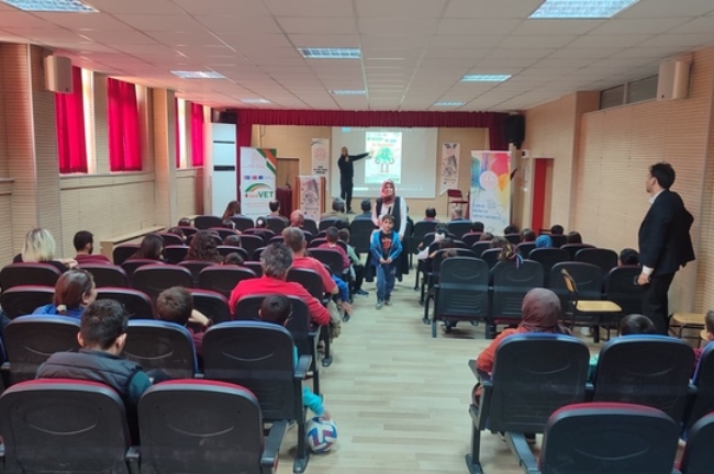 A visual from the Erasmus event showing a professor giving a classroom presentation and the audience listening, held under the theme "One Chance, One Planet, One Responsibility."
