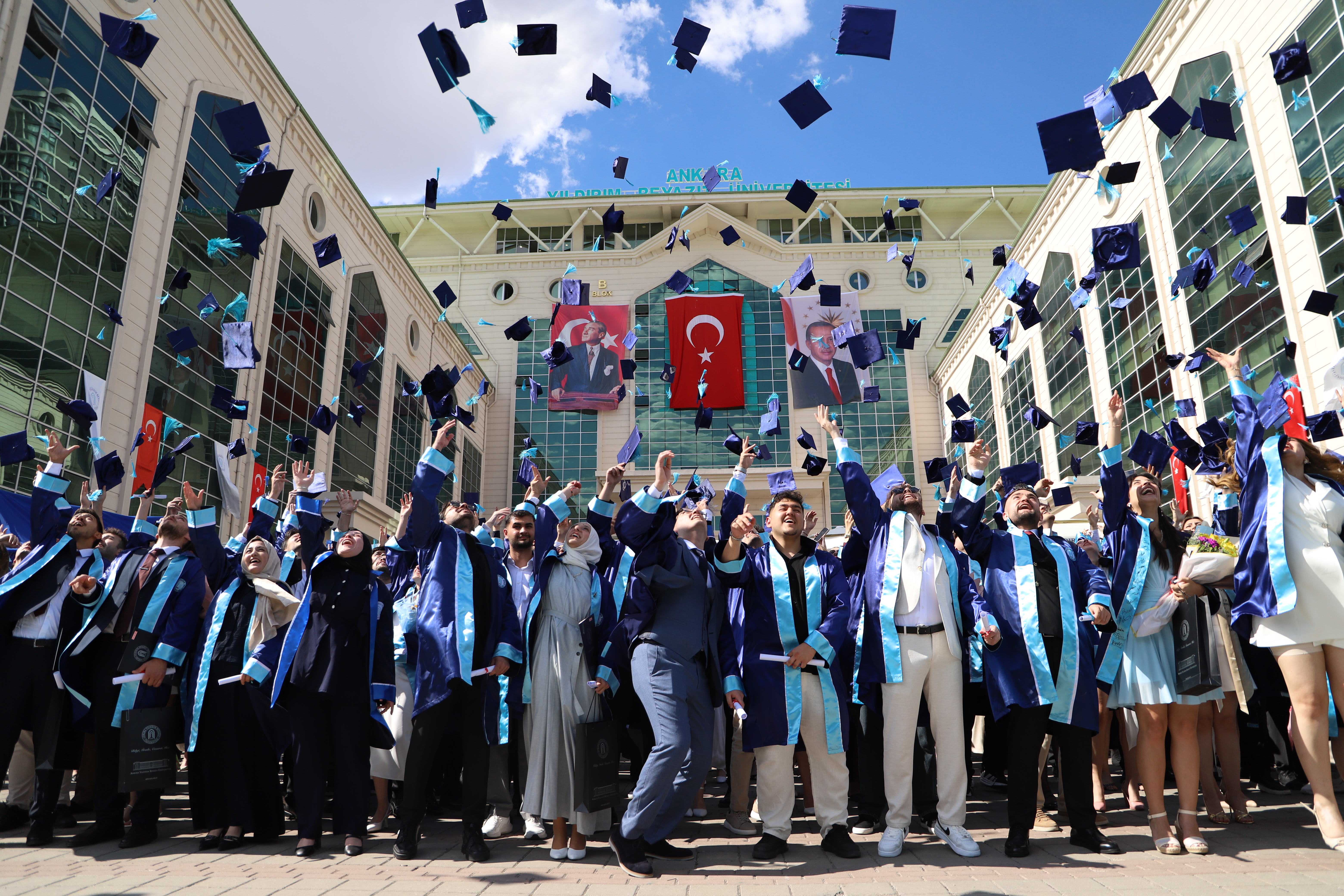 Mezun olan öğrenciler keplerini atıyor.