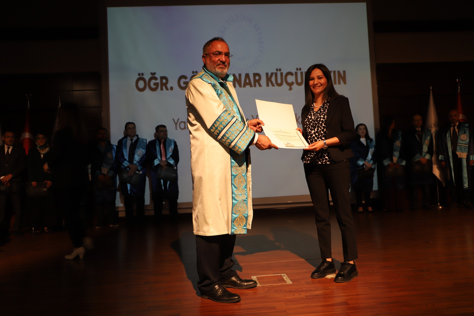 Rektörümüz Prof. Dr. Ali Cengiz Köseoğlu,  Öğr.Gör. Dr. Pınar Küçükakın'a ödül belgesini teslim ettiği fotoğraf
