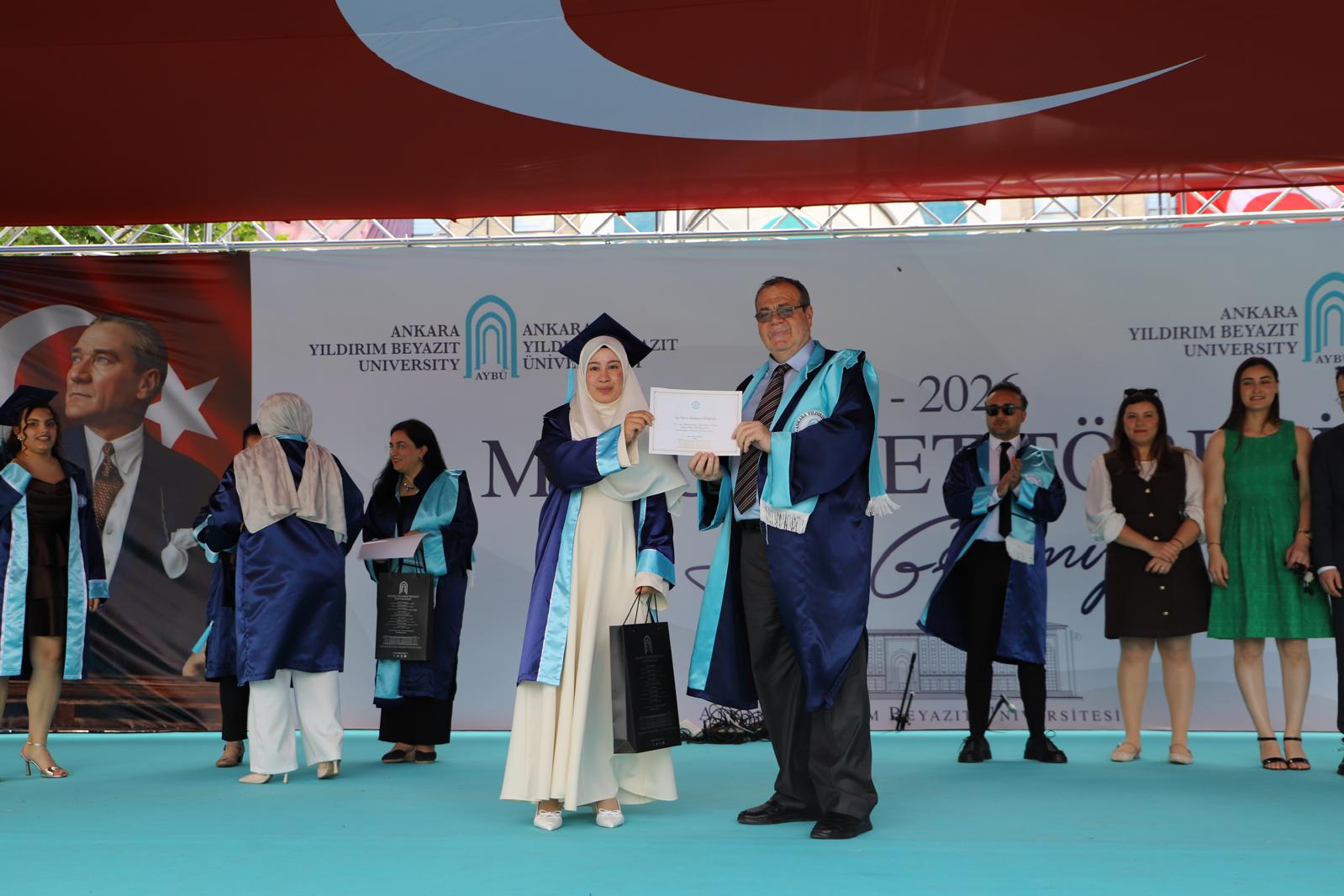 Görsellerde, 2026 yılı Odyoloji Bölümü Lisans Programı mezunları, öğretim elemanlarıyla birlikte mezuniyet töreninde hatıra fotoğrafı çektirmektedir.