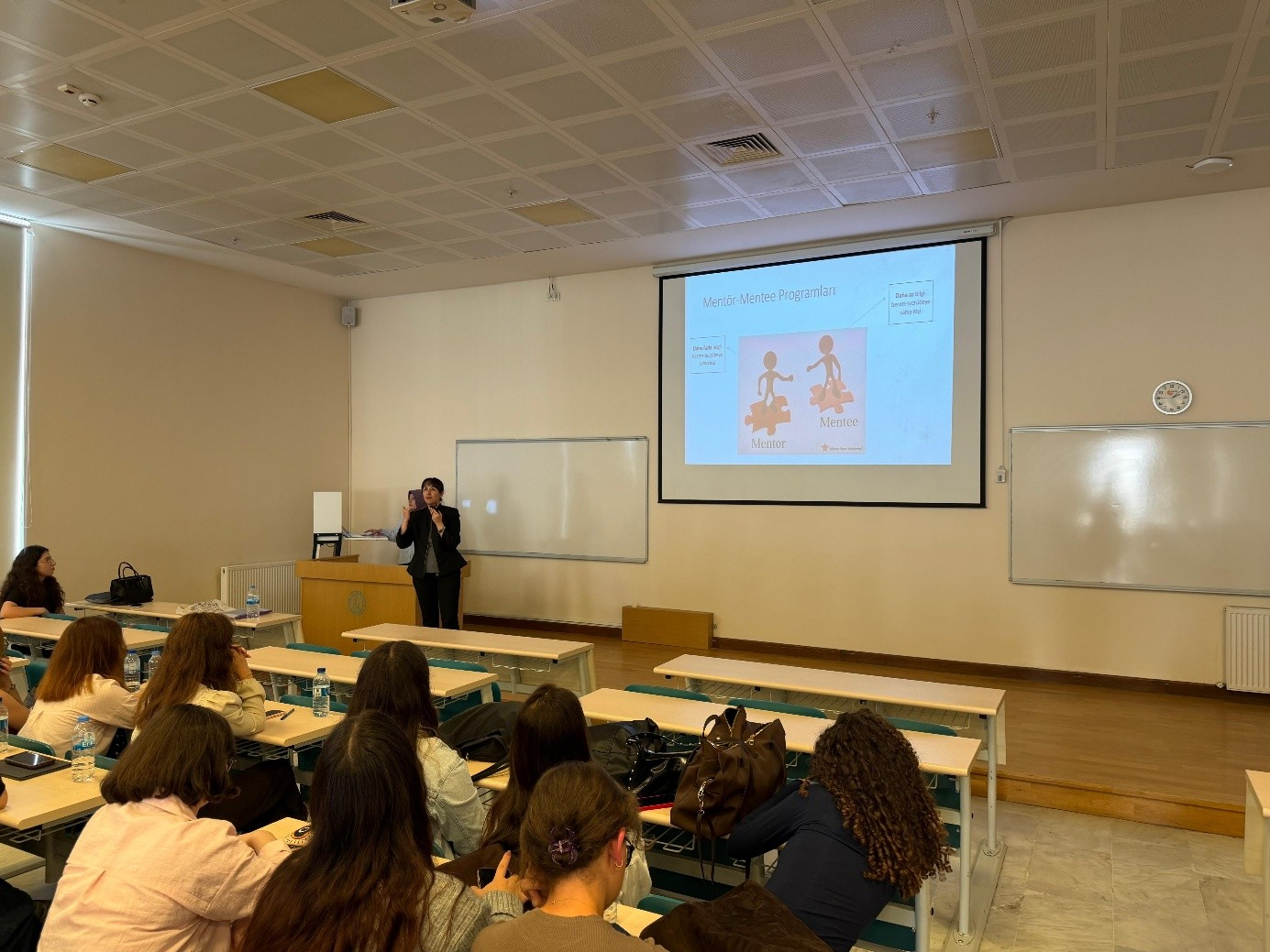 1. sınıf öğrencilerine Doç. Dr. Reyhan Eskiyurt ve Arş. Gör. Şeyma Zübeyde ALBAKIR tarafından Mentör Menti Programı kavramları, menti ve mentör kelime anlamları açıklanıyor.