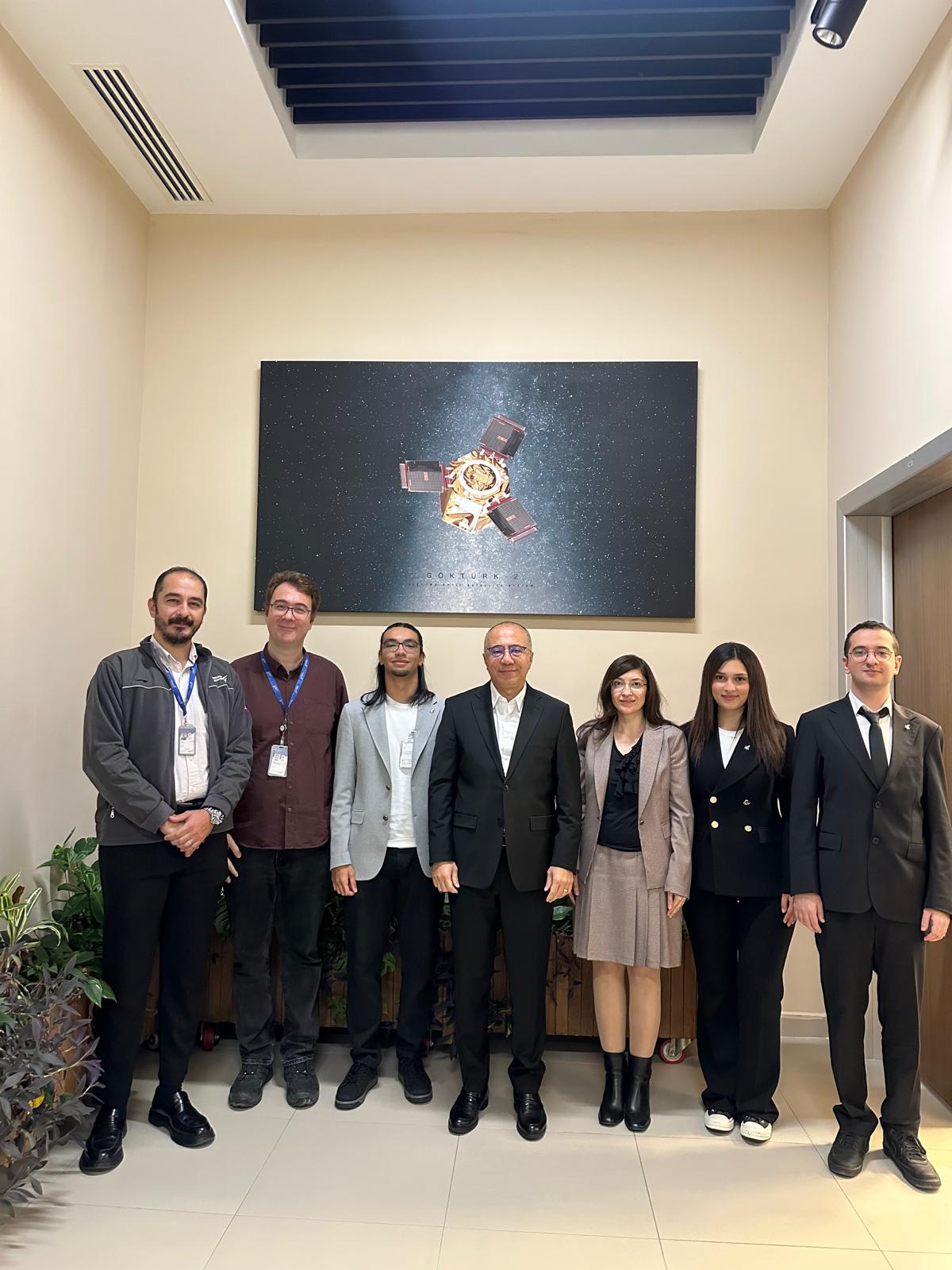 Öğretim üyemiz Doç. Dr. Hilal Arslan, öğrencilerimiz Bekir Berk Yıldırım, Yaren Dinç ve Mert Özdemir, TUSAŞ Uzay Sistemleri Genel Müdür Yardımcısı Dr. Onur Tarakçıoğlu ve ekibinin toplu fotoğrafı.
