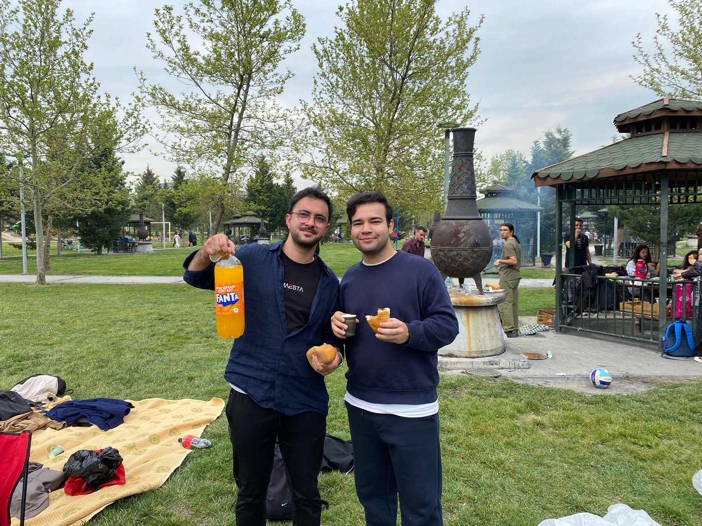 Students relax in the event area while eating sausage sandwiches during the picnic.