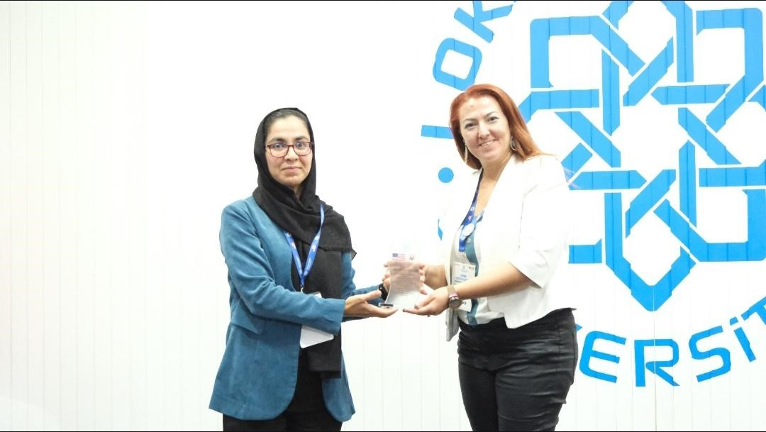 Öğr. Gör. Gamze Güven Yalçın'ın plaket alırken fotoğrafı