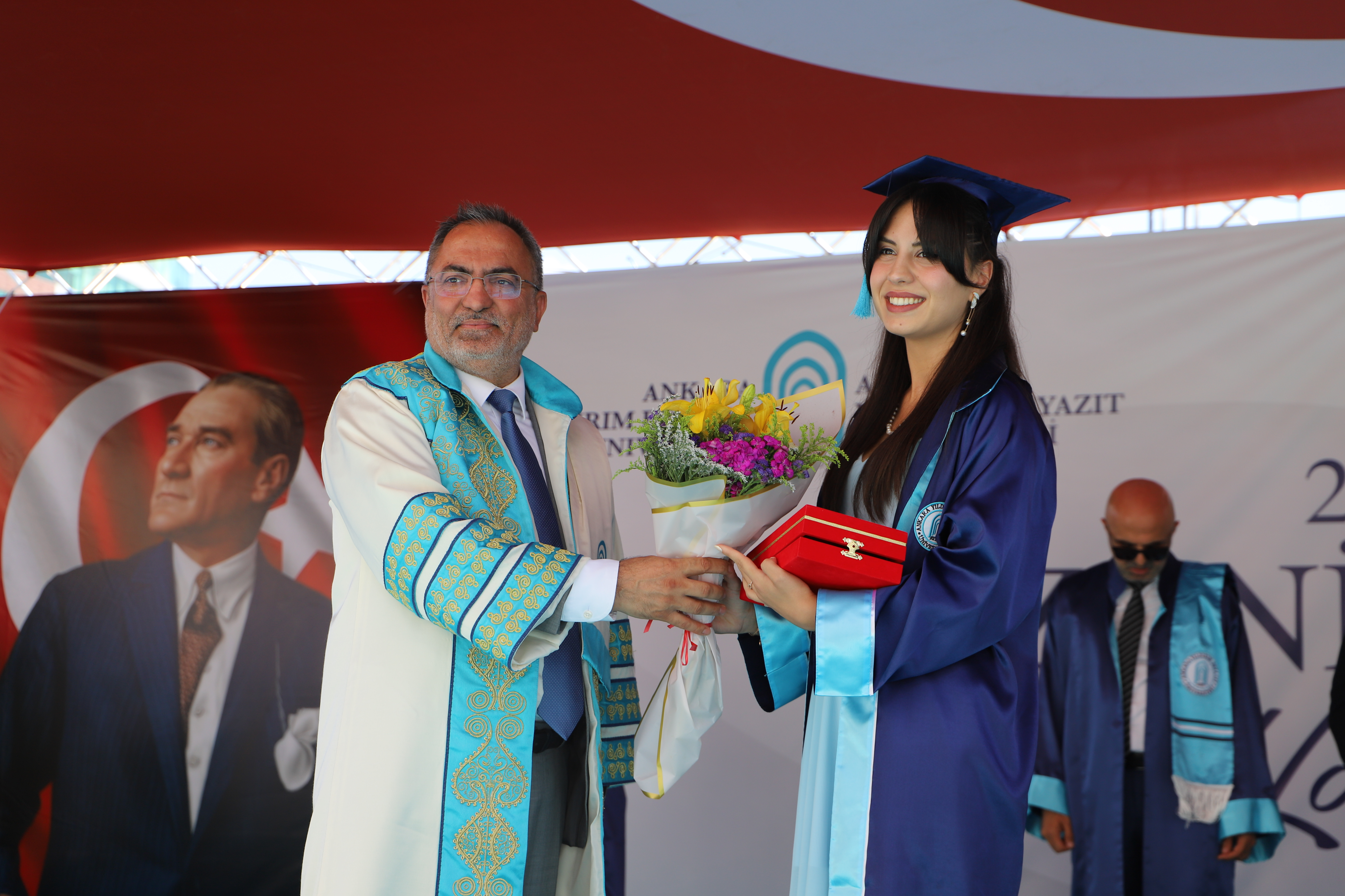 Rektörümüz fakülte birincimiz İlayda Akınet'e plaketini ve çiçeğini takdim ediyor.