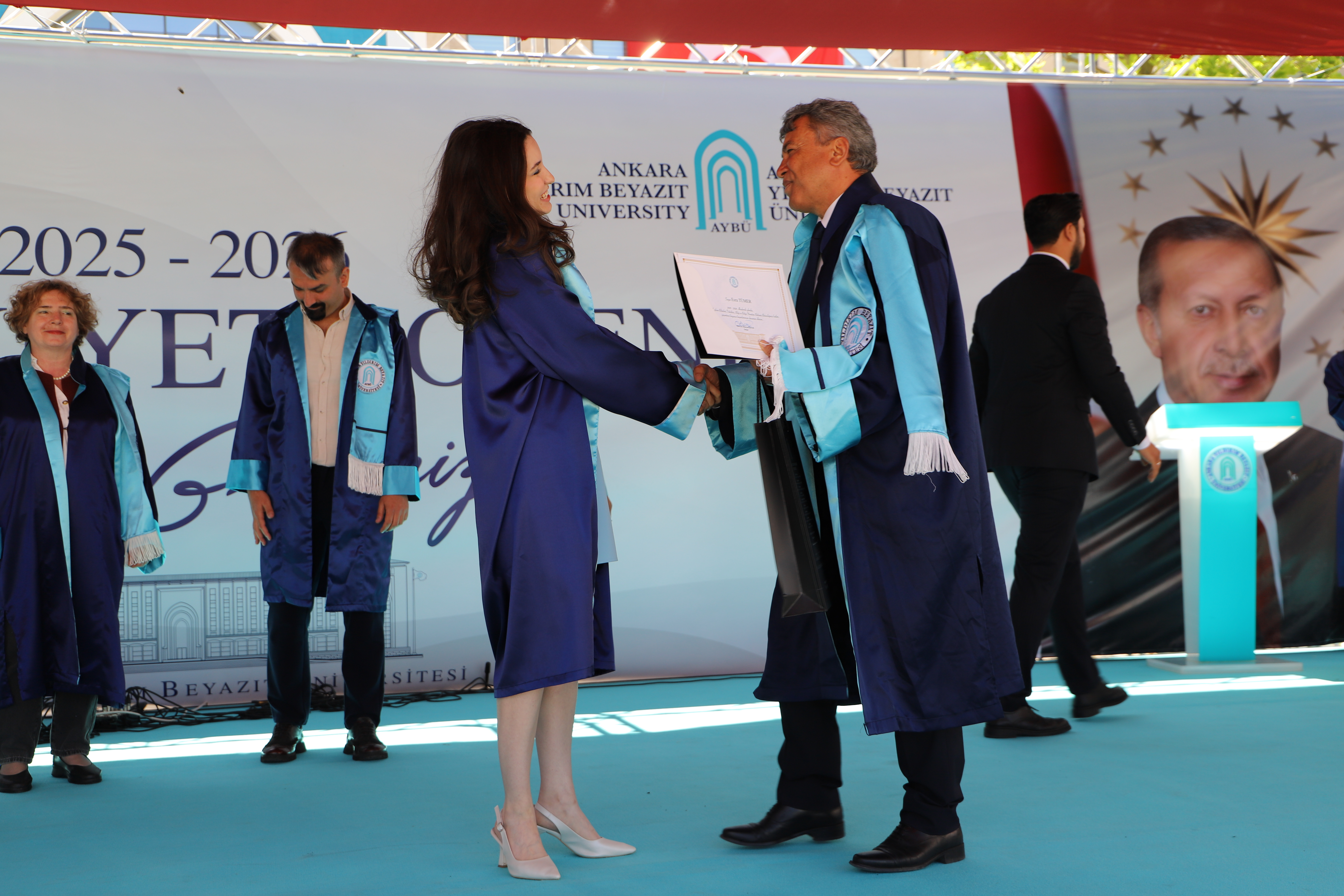 Bölüm ikincisinin Mustafa Bayter'den diplomasını alırken çekilmiş bir fotoğrafı